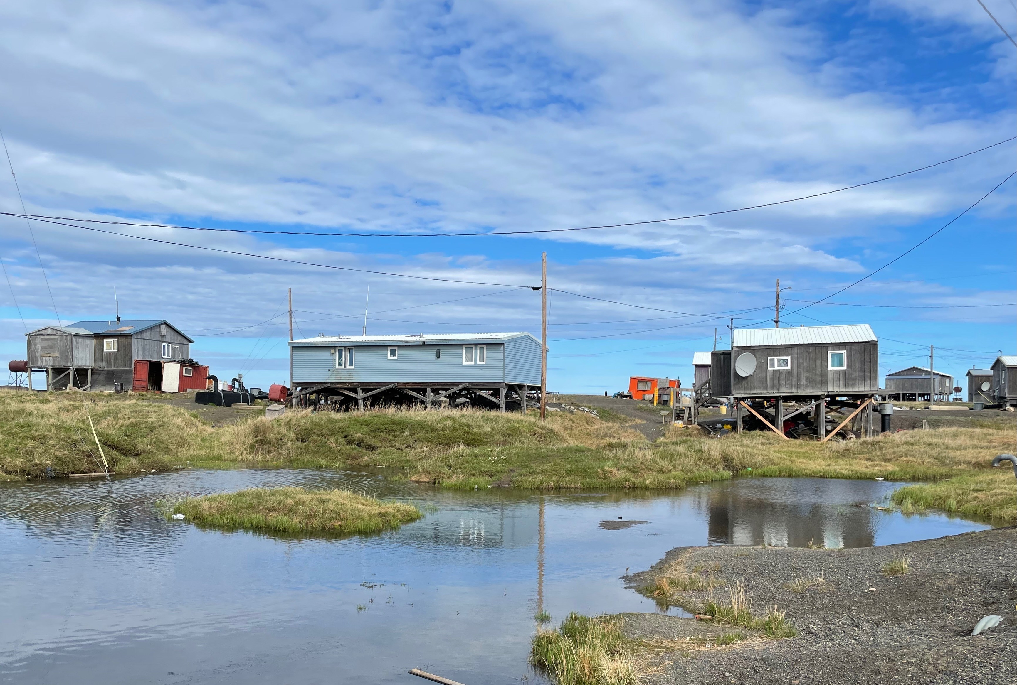 A house at Point Lay is partially surrounded by a thermokarst lake formed by the collapse of permafrost. UAF photo by Benjamin Jones