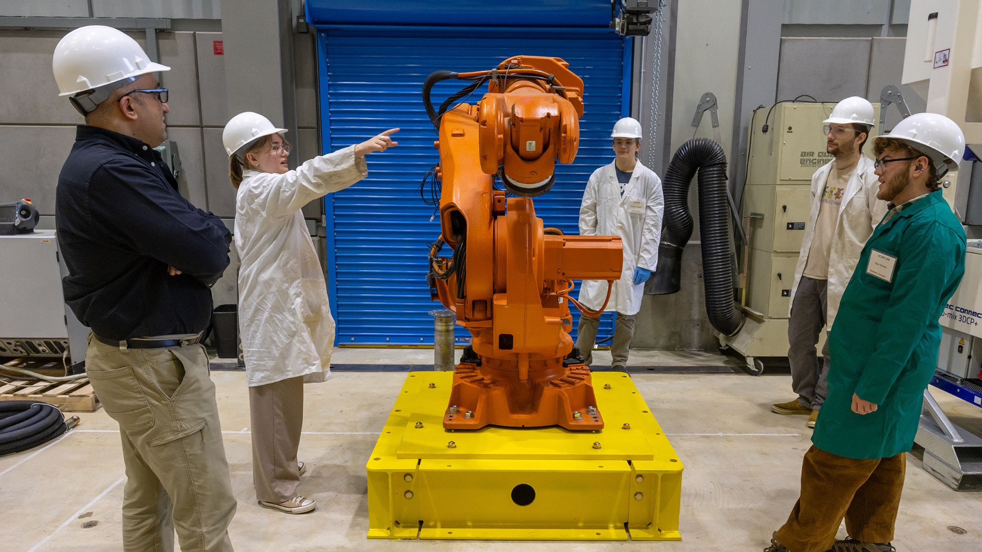 ACAM founder Nima Farzadnia discusses a new 3D concrete printer with students. From left are Farzadnia, Gen Simono, Andrew Zachry, Dylan Frick and Dane Woolery. UAF photo by Eric Engman.