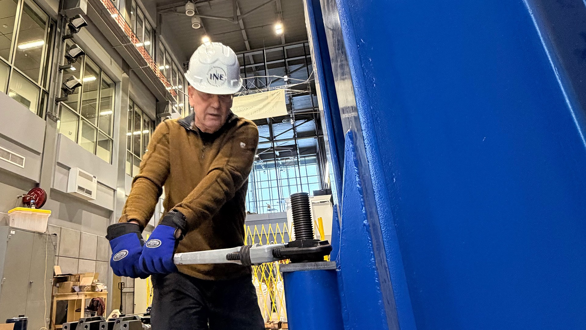 Billy Connor is securing one of the massive steel girders in place. UAF/INE photo by Kate Avery.